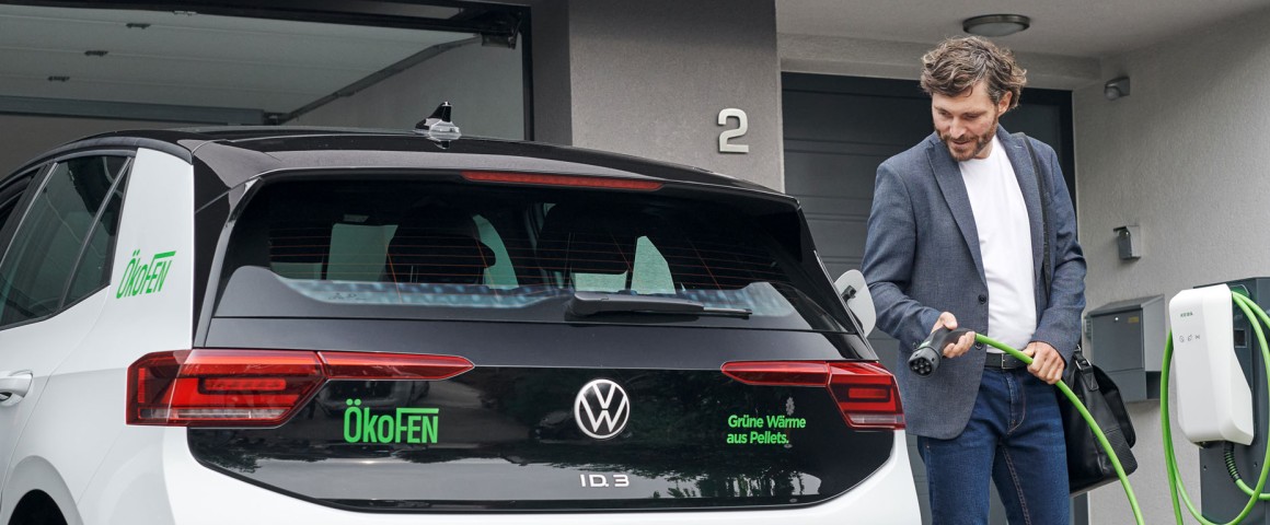 Herr im Anzug lädt sein Auto in der privaten Garage.