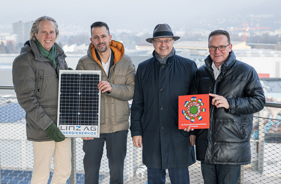 Vertreter der Linz AG und der Sparkasse Oberösterreich stehen nebeneinander und halten ein Photovotaik-Panle und ein Bild des Umweltzeichens in Händen