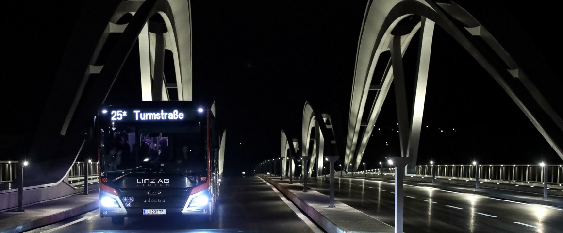 Abbildung von einem LINZ AG Linien Bus, welcher zum Ersten Mal über die neue Eisenbahnbrücke fährt.