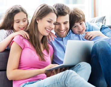 Bild einer Familie, die auf einen Laptop schaut