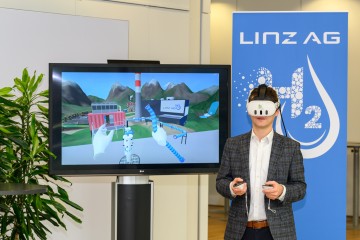 LINZ AG-Wasserstoffbeauftragter DI Dominik Matheisl, BSc testet die VR-Brille, bevor sie auf der H2 Convention am LINZ AG-Ausstellungsstand der Öffentlichkeit zugänglich gemacht wird.