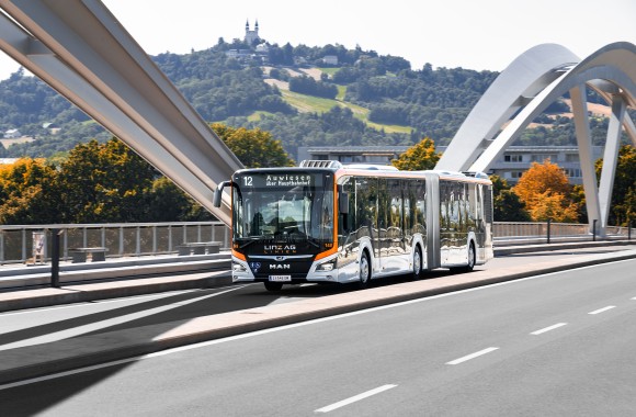 Ein Bus der LINZ AG Linien fährt über die Eisenbahnbrücke.