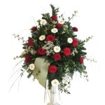 grünes Bukett mit roten Rosen und weißen Gerbera und kurzer weißer Schleife