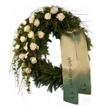 grüner Kranz mit weißen Rosen und hängenden Gräsern, dazu eine beige Schleife mit Aufschrift "liebe letzte Grüße"