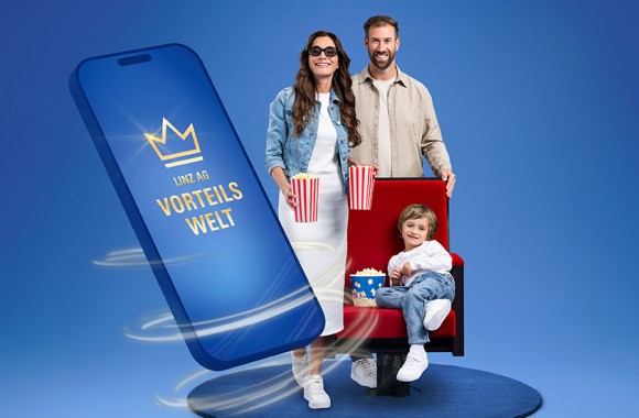 Ein junges Paar steht bei einem Kinosessel und hält eine Popcorntüte in der Hand. Im Sessel sitzt ihr Sohn. Neben der Familie ist ein überdimensionales Smartphone mit Vorteilswelt-Schriftzug zu sehen.